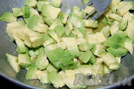 Нарезаем  авокадо для салата небольшими кусочками, складываем в миску, добавляем лимонный сок и оливковое масло, перемешиваем.
