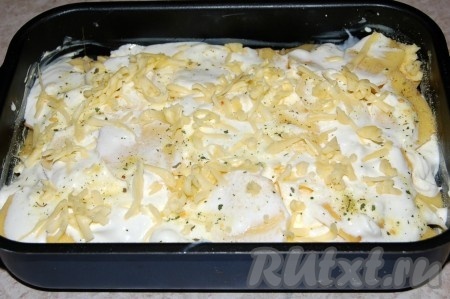 Снова полить картофель сметаной, добавить специи, соль и посыпать сыром.