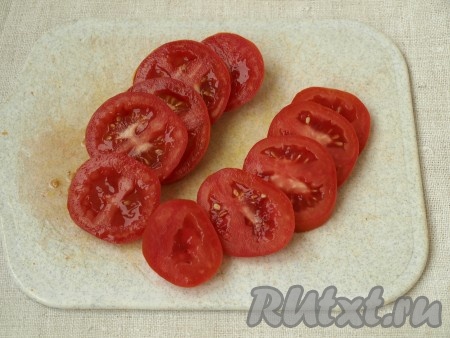 Пока баклажаны запекаются, нарезать кружками помидоры.
