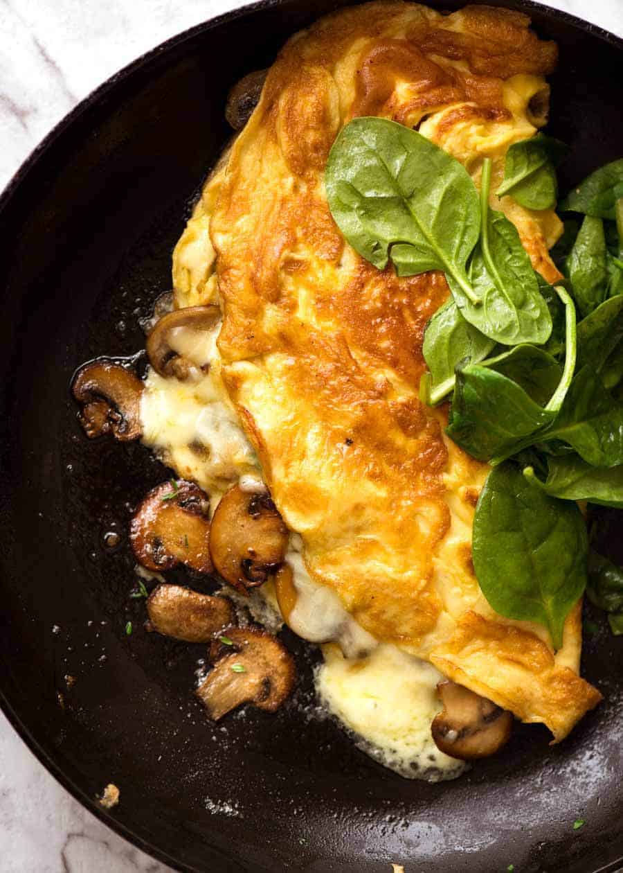 Overhead photo of Cheesy Omelette with Garlic Butter Mushrooms in a skillet.