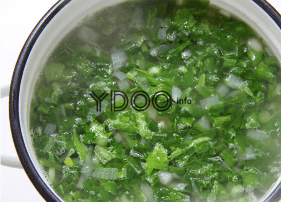 суп в кастрюле с добавлением большого количества зелени